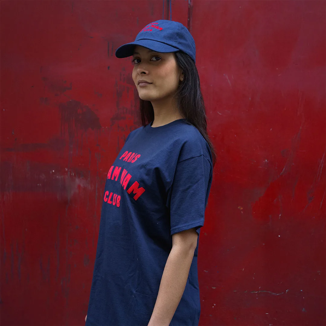 Model profile wearing a cap and a navy blue Paris Miam Miam Club T-shirt